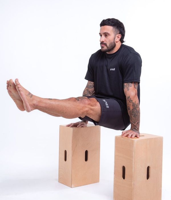 Man performing controlled strength movements in a modern gym setting.